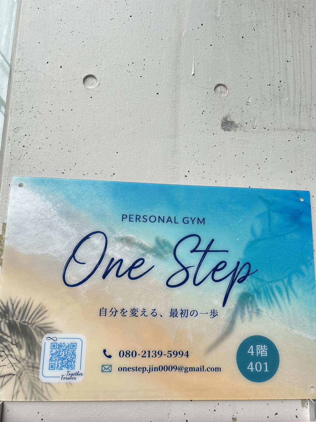 ビルの入口に掲示されたOne Stepの看板。4階401号室